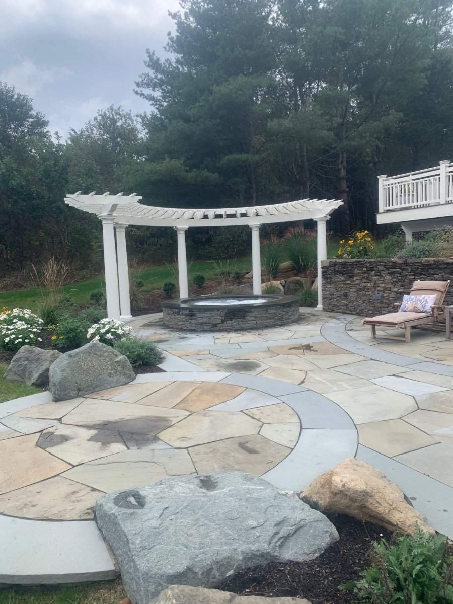 This patio features a raised hot tub, custom arbor and coastal themed gardens.
